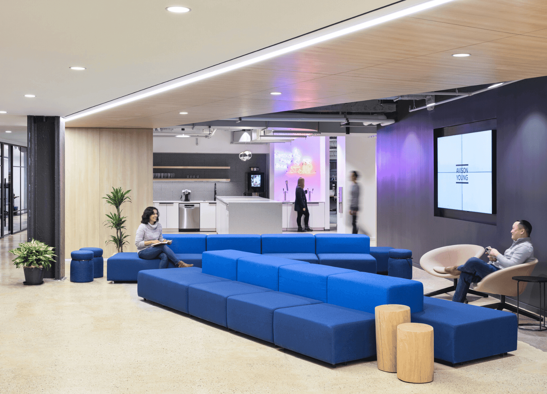 Modern reception area with 'AVISON YOUNG' signage, marble counter, and seating lounge