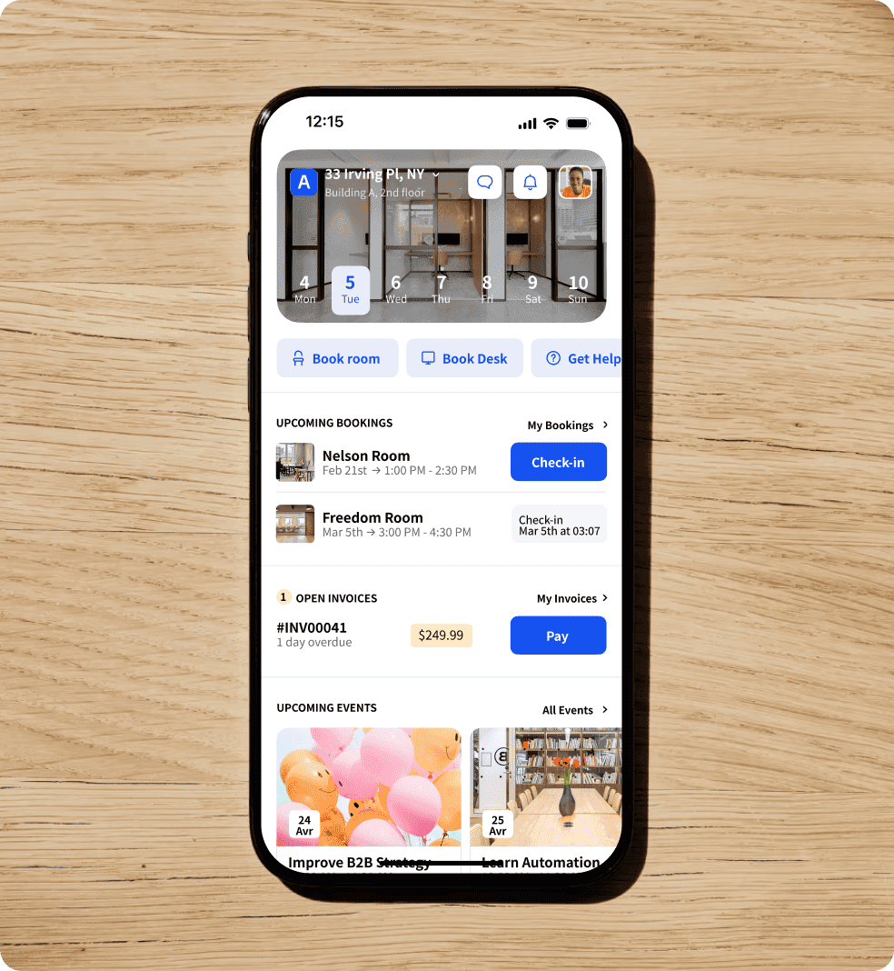 Three colleagues in modern office talking around laptop during casual meeting.