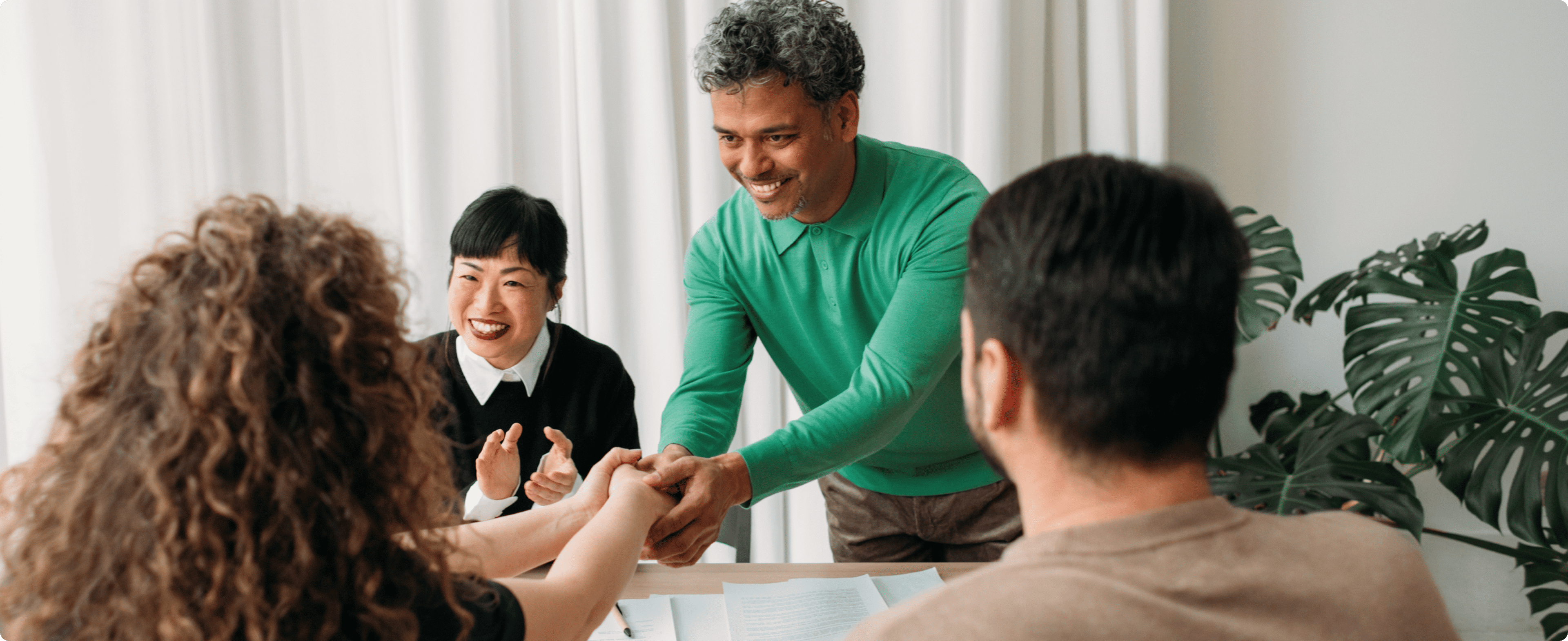 Smartphone on wooden surface displaying Archie app with bookings, invoices, and upcoming events dashboard.