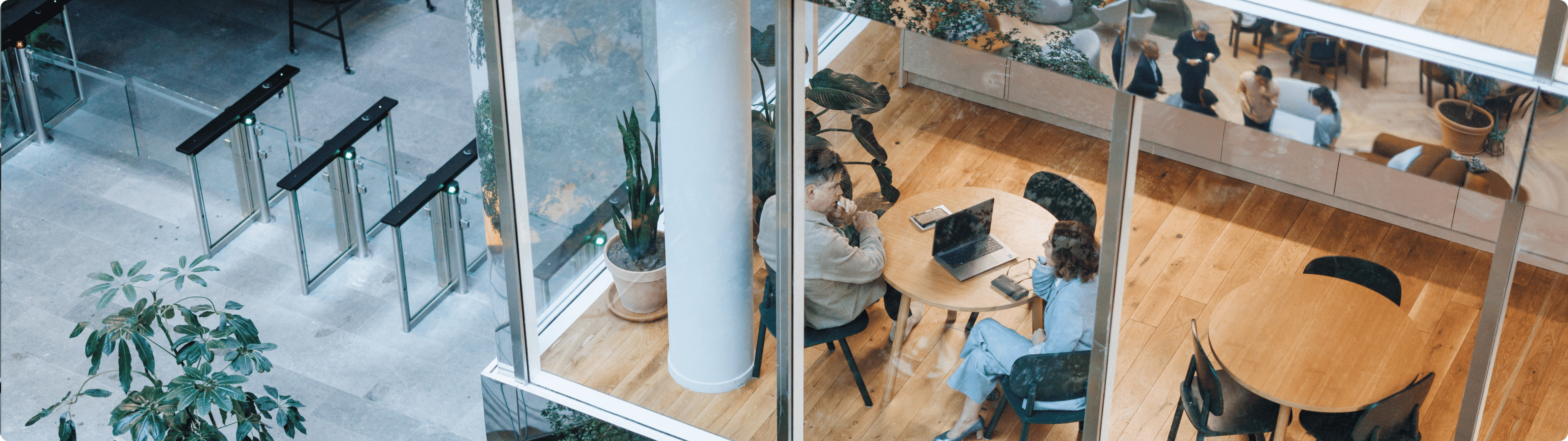 Overhead view of office lobby with glass walls and people sitting at round tables