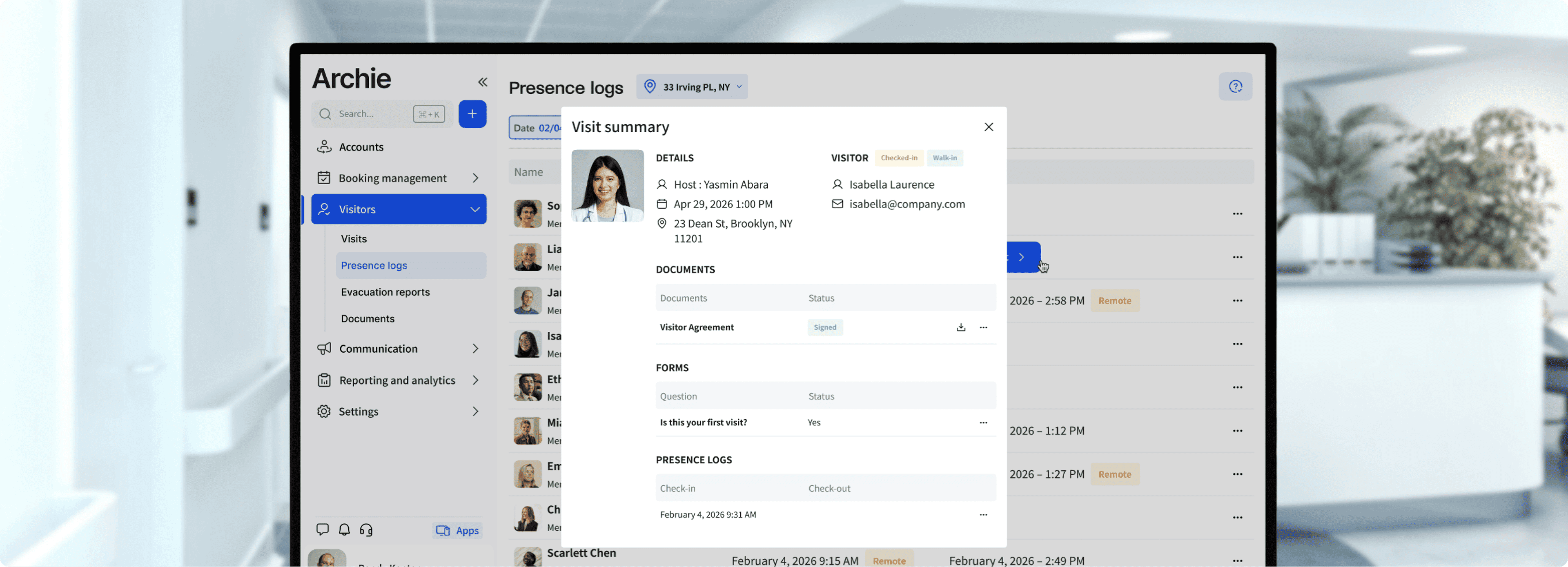 Healthcare worker in blue scrubs wearing a headset and sitting at a workstation