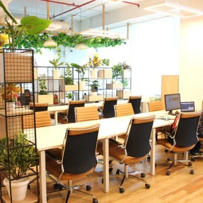 A bright coworking space with desks and tan-and-black office chairs.