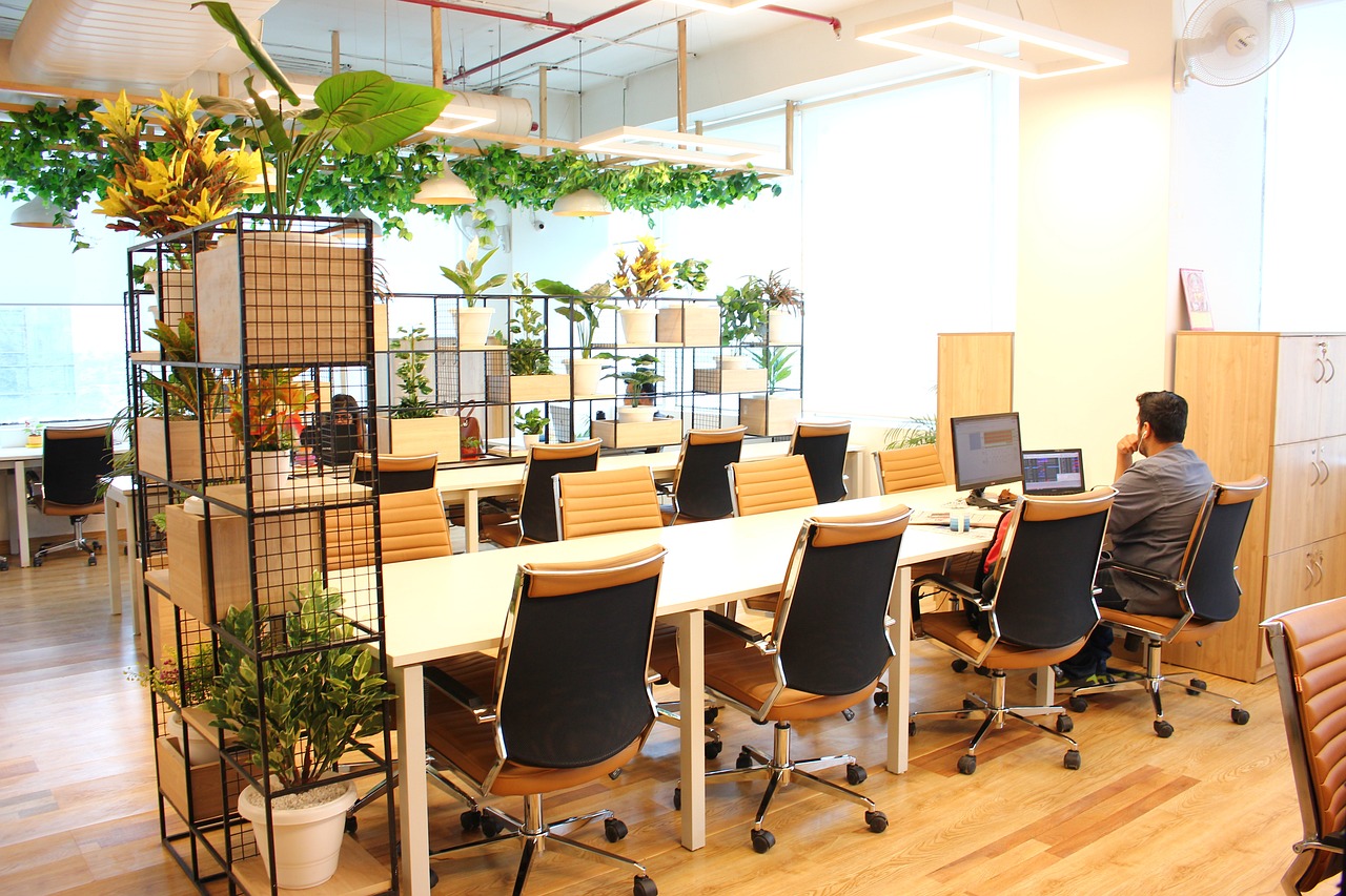 A bright coworking space with desks and tan-and-black office chairs.