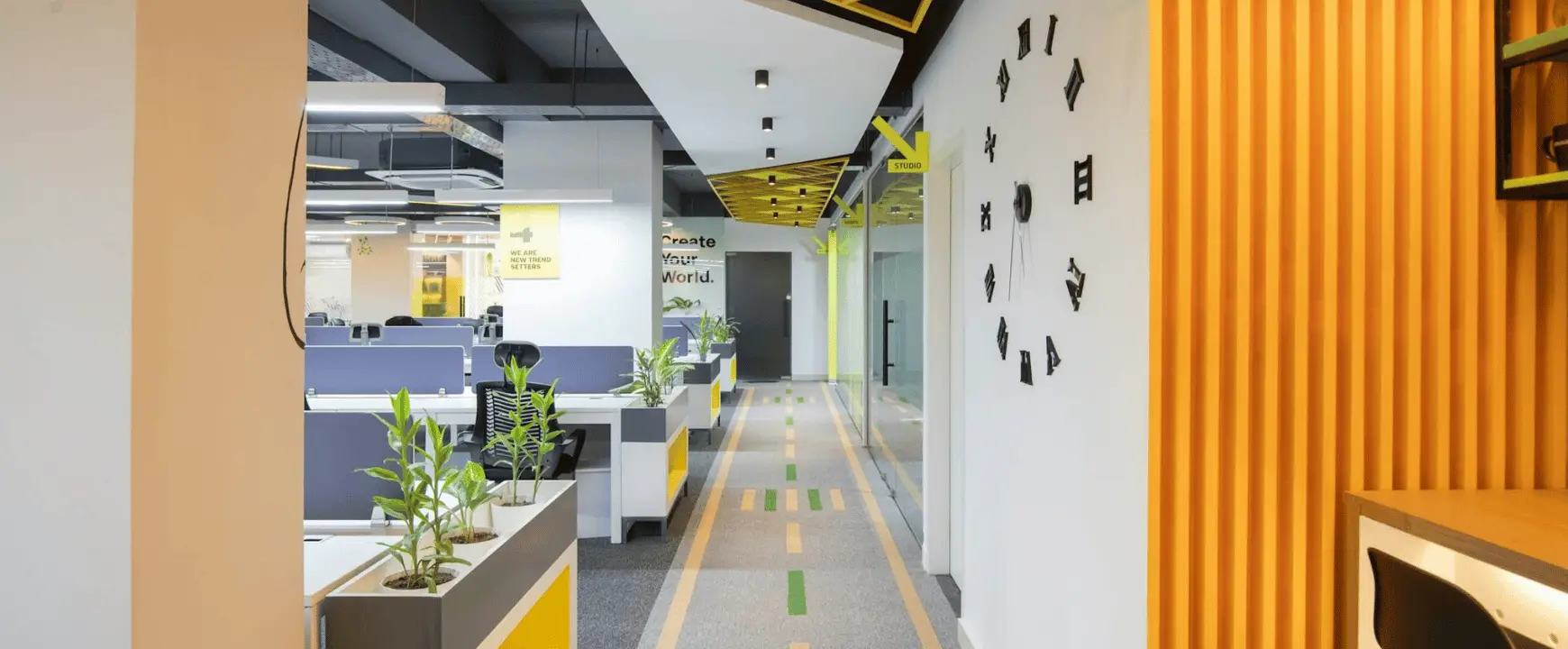 Modern coworking space interior with open workstations, private offices, and clearly marked shared amenities.