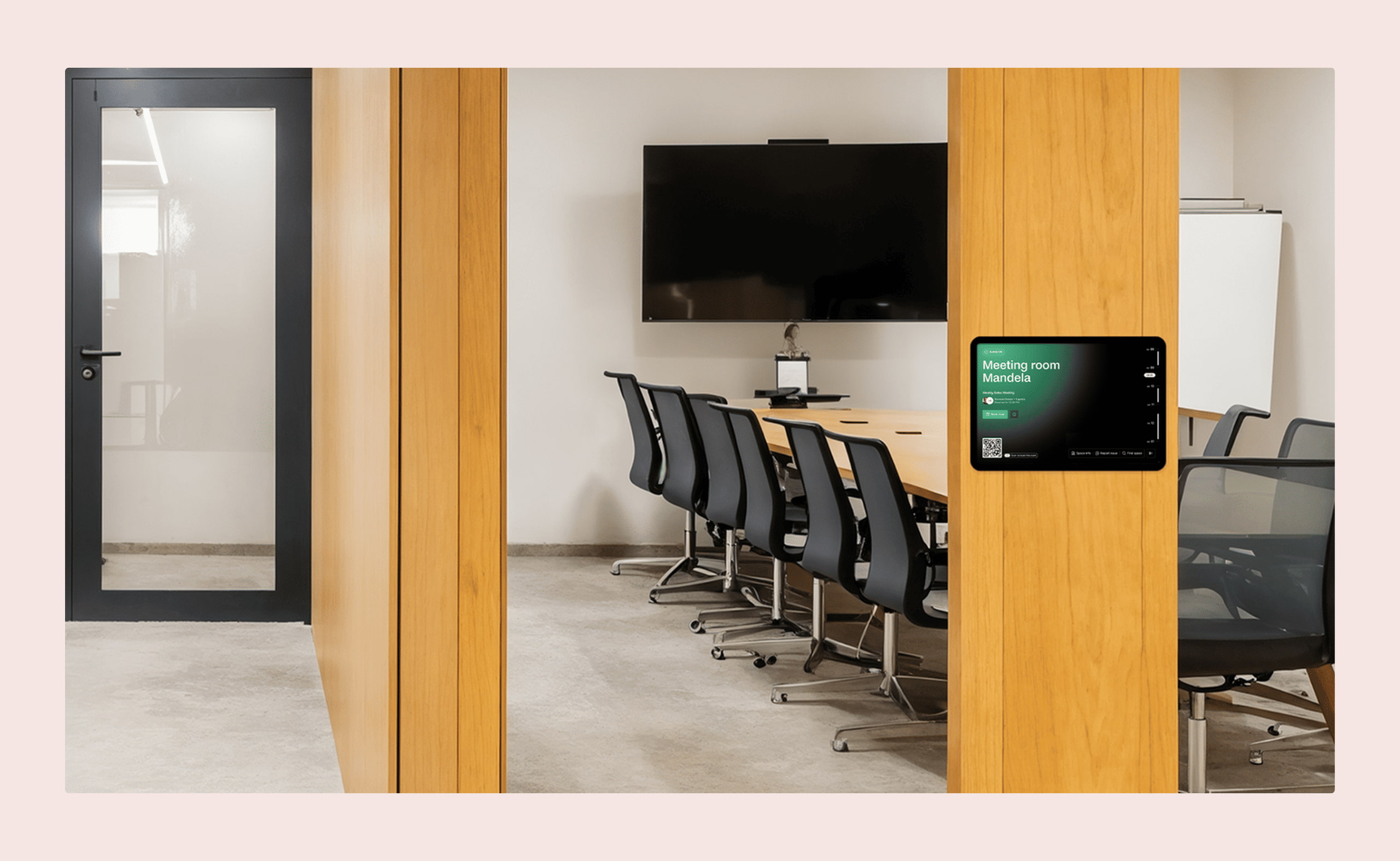 Modern meeting room with a wall-mounted room booking display showing availability for “Meeting room Mandela.”