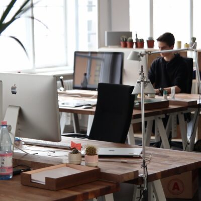 A modern office space with people working behind hot desks.