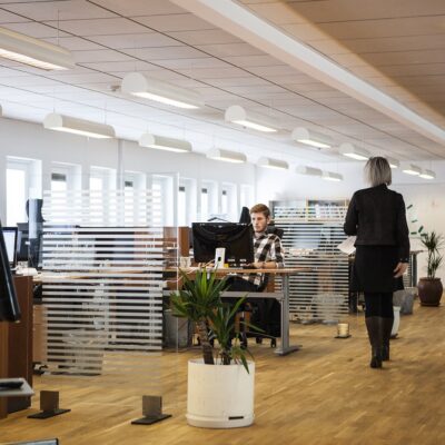 A modern open-plan office space with employees working at their desks.