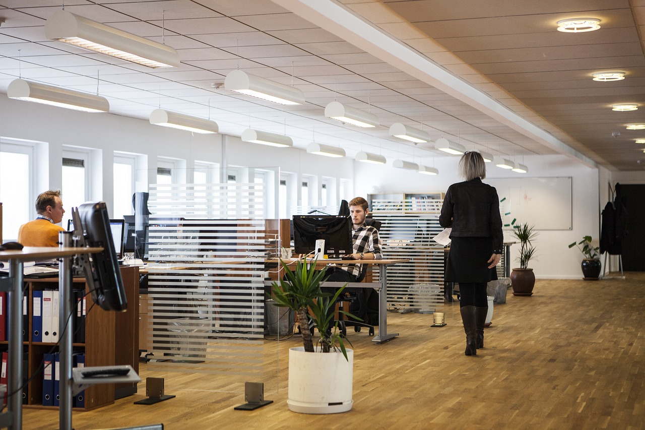 A modern open-plan office space with employees working at their desks.