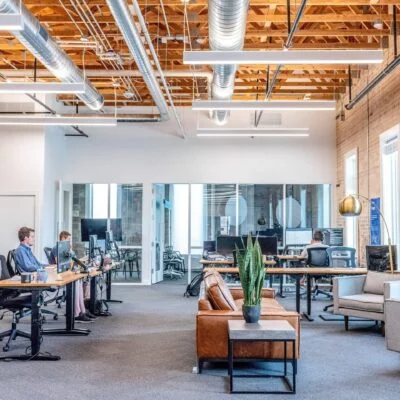 An open-plan office with workstations and employees working at desks equipped with computers.