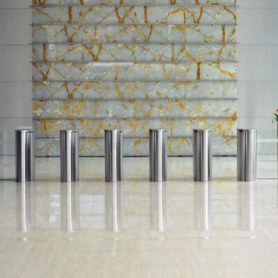 A modern building lobby with a sleek security entrance featuring metal turnstiles.