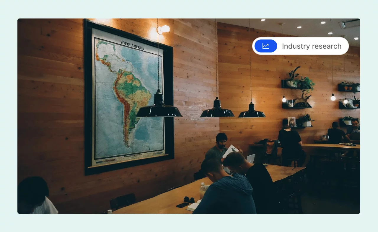 A cozy coworking space with wooden walls, warm lighting, and a large map of South America.