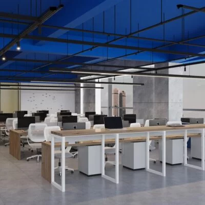 Modern open-plan office with rows of desks, white chairs, and desktop computers under a blue ceiling.