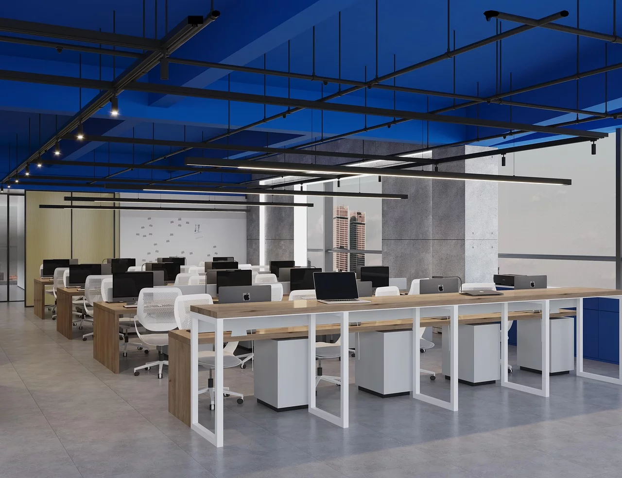 Modern open-plan office with rows of desks, white chairs, and desktop computers under a blue ceiling.