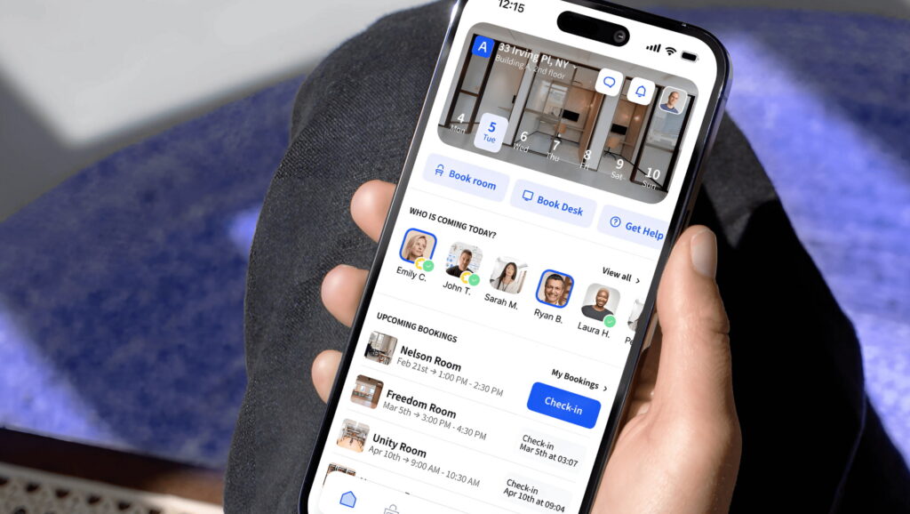 Hand holding a smartphone showing the Archie app interface with desk and room booking options.