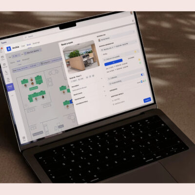 A laptop screen showing Archie software’s room booking feature with a floor plan, next to a G2 “Best Results” badge for Summer 2025.