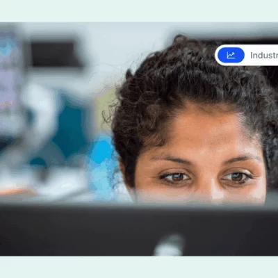 Close-up of a woman focused on her computer screen in an office setting.