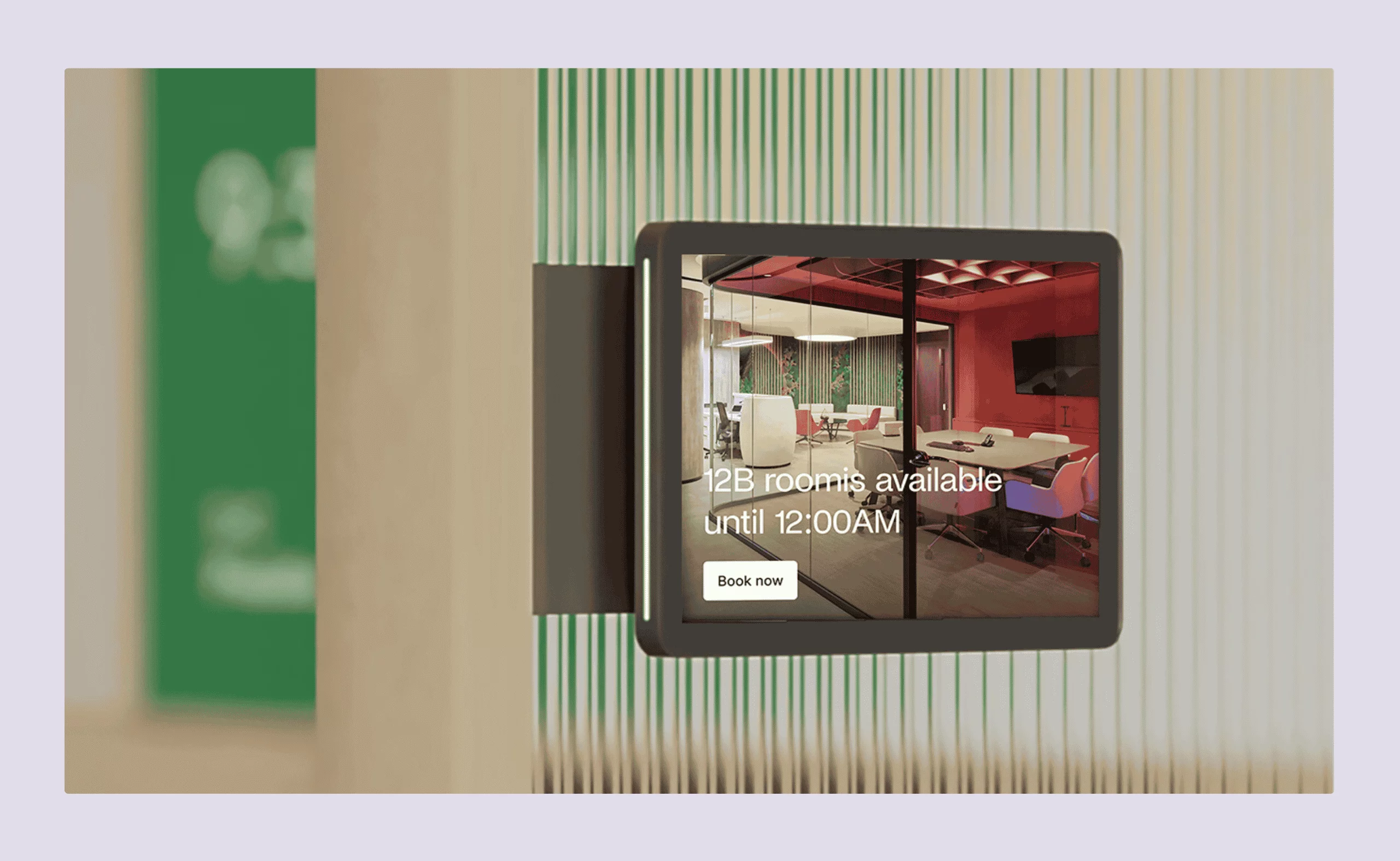 A digital room display panel showing a meeting room's availability and a “Book now” button.