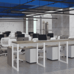 Moderna oficina diáfana con filas de escritorios, sillas blancas y ordenadores de sobremesa bajo un techo azul.