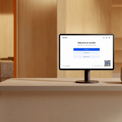 Reception desk running Archie’s visitor check-in app and badge printer in a modern office lobby.