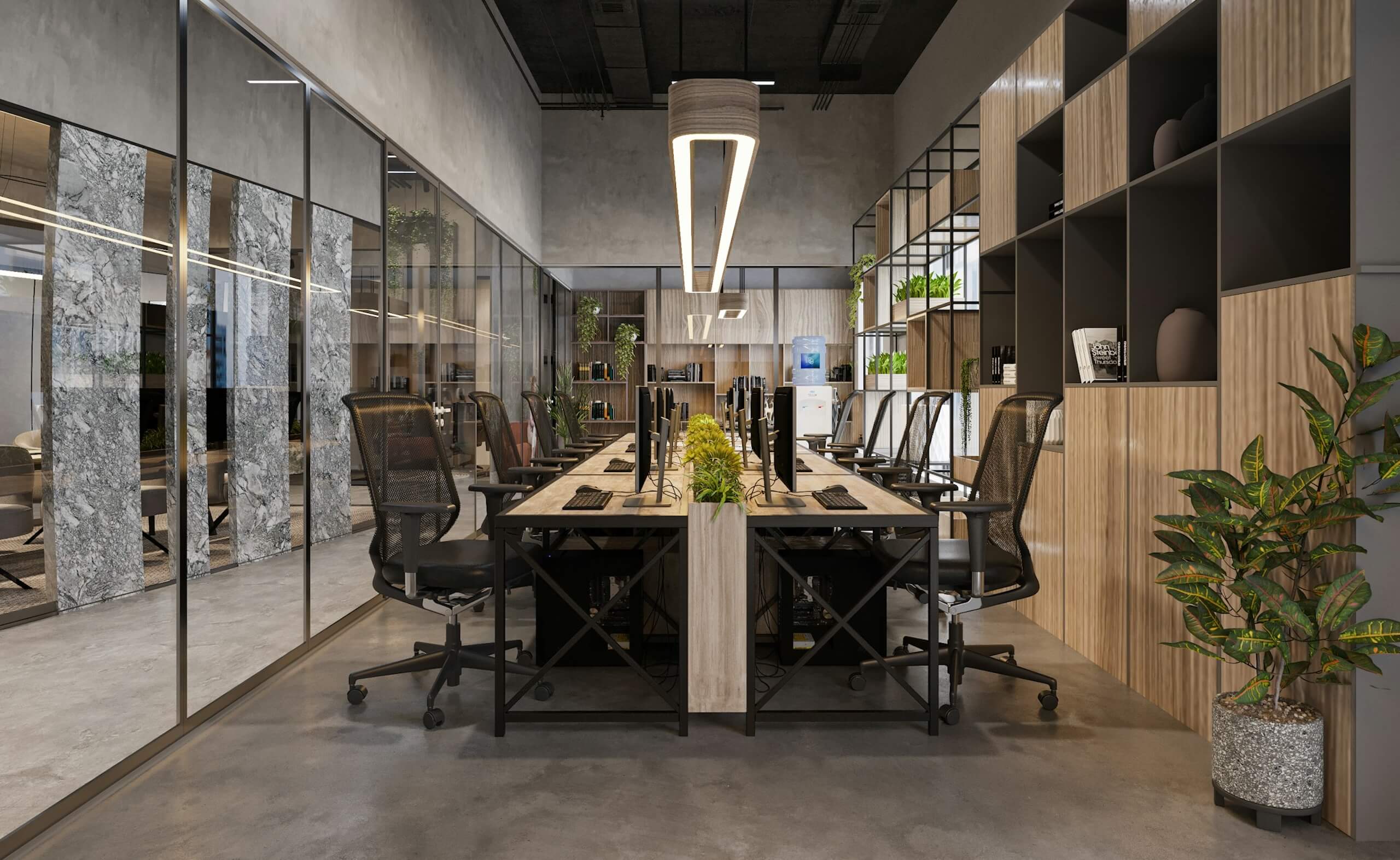 Modern office workspace with shared desks, computer monitors, and glass meeting rooms.