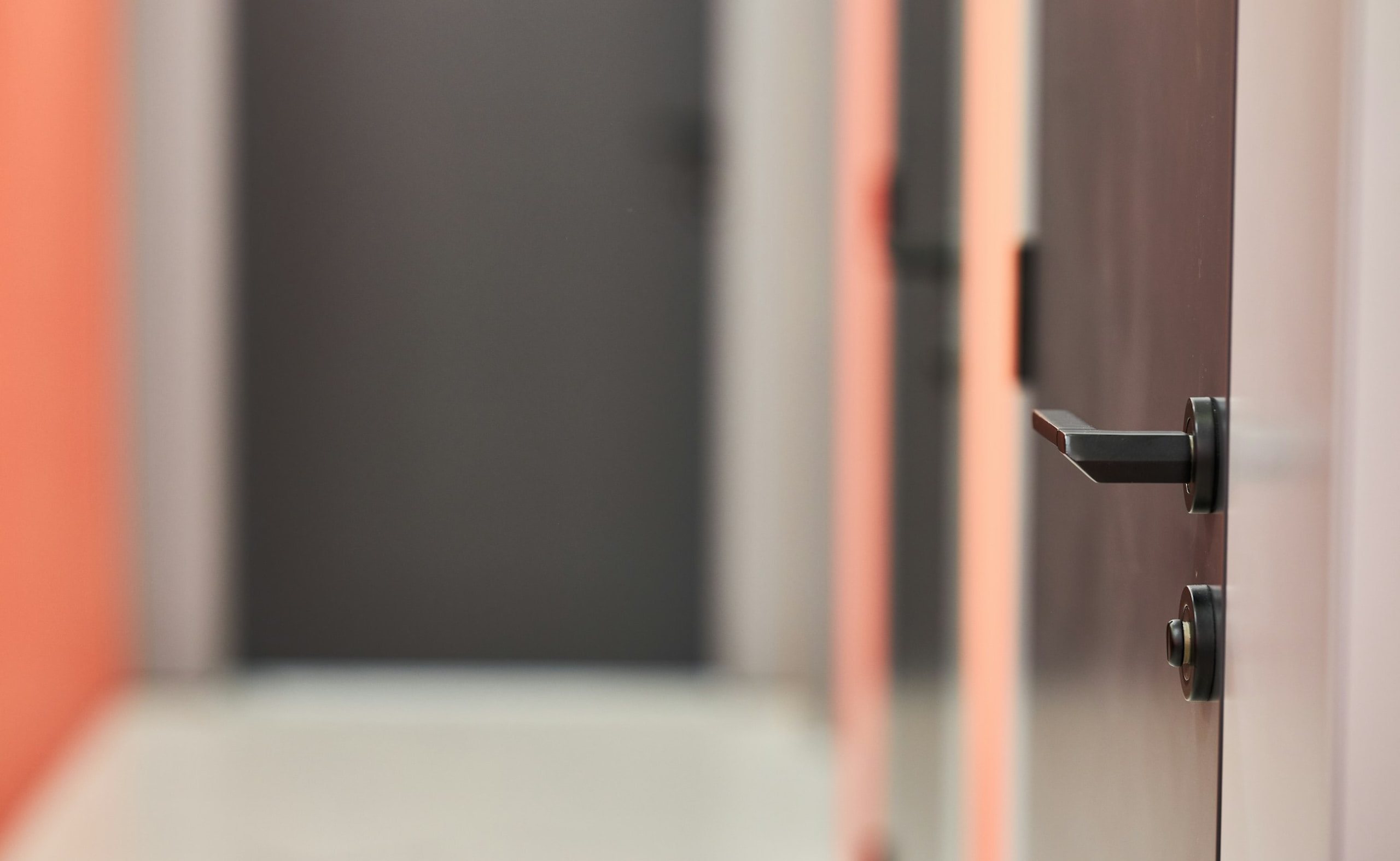 Close-up of an office door handle in a hallway, representing workplace access control and security.