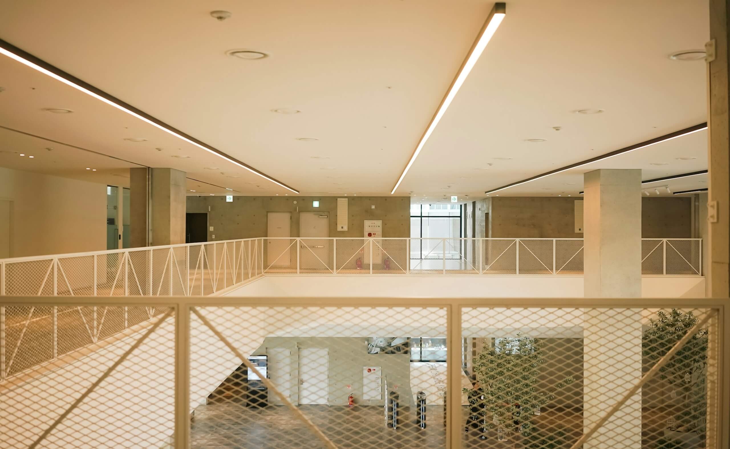 Modern office interior with open atrium, railings, and minimalist design.