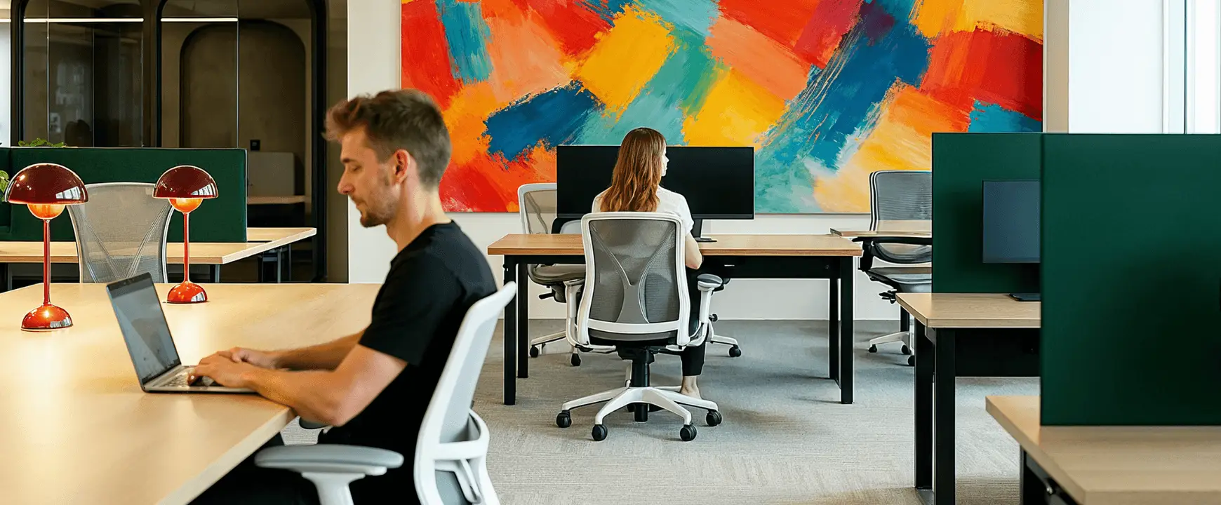 Modern office workspace with employees working at shared desks, highlighting flexible office management and workplace operations.